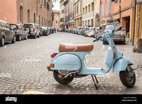 A Light Blue Vespa Motor Scooter Parked On A Street In Bologna Italy