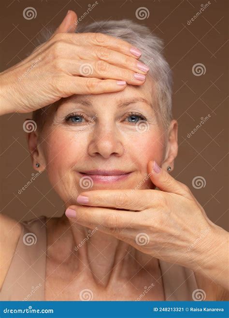 Portrait Of Beautiful Senior Woman Touching Her Perfect Skin And