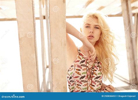 Closeup Portrait Of A Blonde With Curly Hair Posing On A Wooden