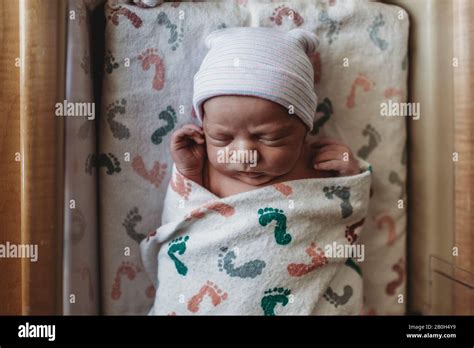 Overhead View Of Newborn Boy With Hat In Hospital Bassinet Stock Photo