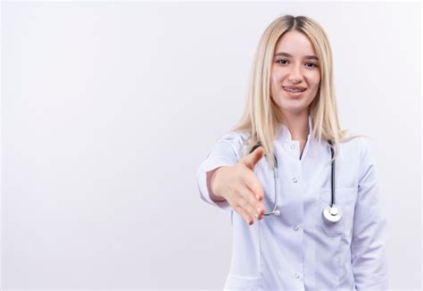 Souriant médecin jeune fille blonde portant un stéthoscope et une robe médicale en orthèse