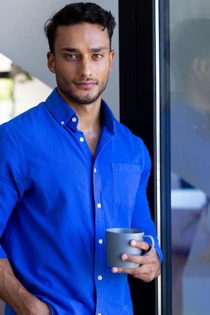 Premium Photo Portrait Of Happy Biracial Man Holding Mug And Looking