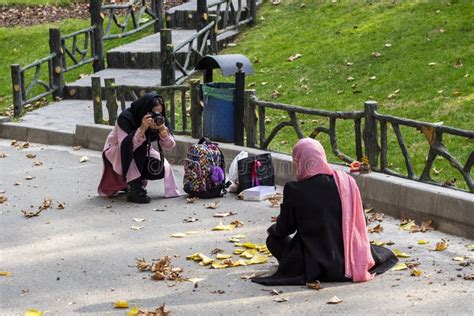 Two Young Iranian Women In Chador Are Taking Photos In The Park