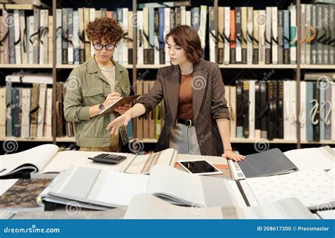 Jovencita Brunette Asistente De Tienda Femenina Haciendo Notas Sobre Muestras De Papel Tapiz