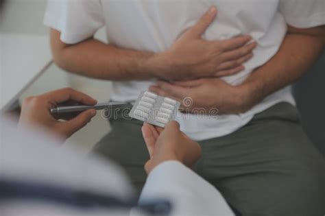 Man Suffering With Severe Stomach Pain Sitting At Home Hand Of Mature