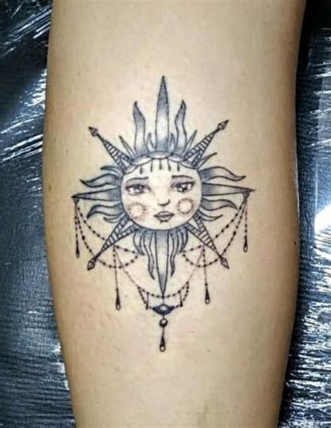 A Tattoo On The Leg Of A Woman With Sun And Moon Designs Around Her Body