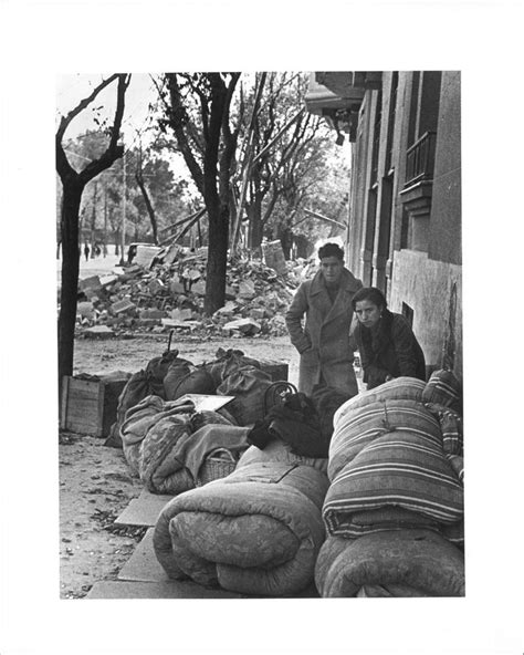 Black And White Photograph Of Two Men Standing Next To Bean Bags On The