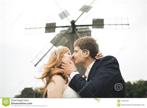 Lovely Wedding Couple Bride And Groom Posing In Field During Sunset