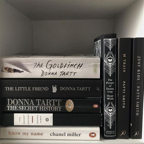 A Stack Of Books Sitting On Top Of A White Book Shelf Next To Each Other