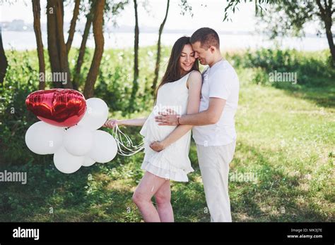 Happy And Young Pregnant Couple Hugging In Nature Romantic Moments