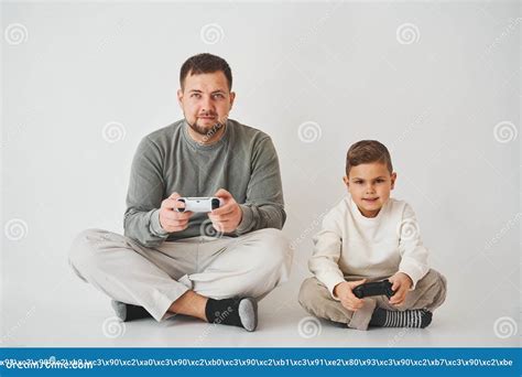 Filho E Pai Jogam Jogos De Console Com Gamepad Menino E Seu Pai Passam