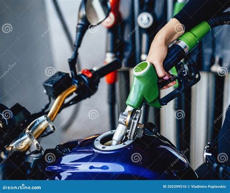 Closeup Of Motorcycle Is Fueling By A Human Stock Photo Image Of