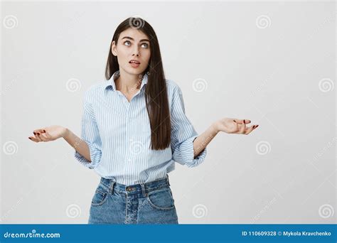 Indoor Portrait Of Hesitant Woman With Questioned Expression Lifting