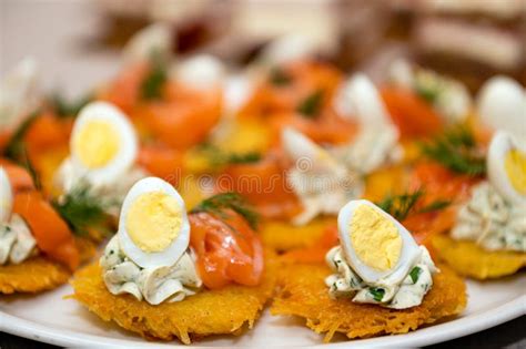 Closeup Of Appetizers Of Potato Pancakes Eggs And Seafood Lined Up On