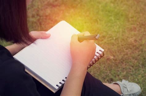 Premium Photo Close Up Of Woman Writing In Book