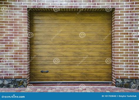 Dark Wooden Garage Door With Colored Brick Wall Background Stock Photo