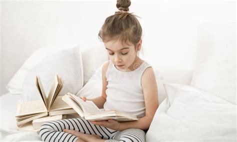 Cute Little Girl Reading a Book on the Bed in the Bedroom Stock Image - Image of close, looking ...