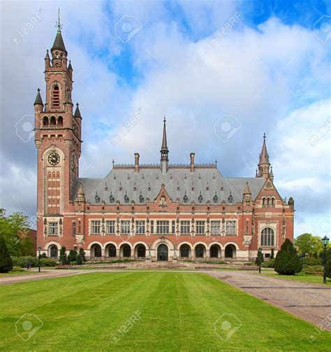 an old building with a clock tower in the middle of it's front lawn