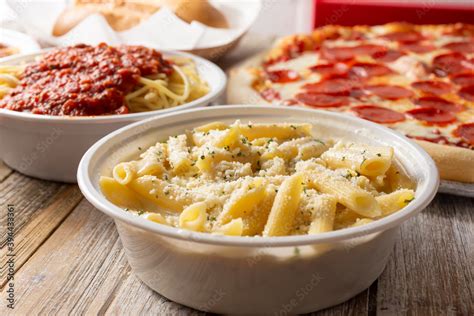 A view of several prepared Italian restaurant entrees, featuring penne ...