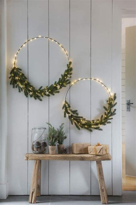 Two Christmas Wreaths Are Hanging On The Wall Above A Table With