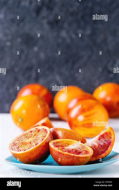 Sliced And Whole Ripe Juicy Sicilian Blood Oranges Fruits On Ceramic