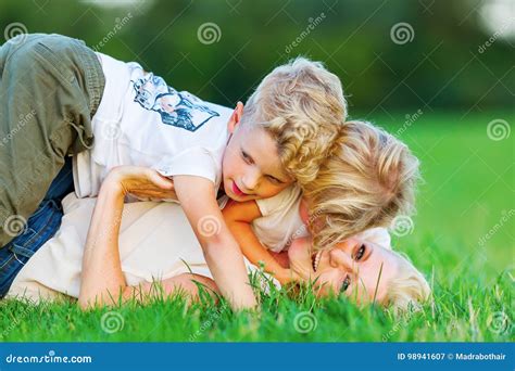 Woman Romps With Her Two Sons On The Grass Stock Image Image Of