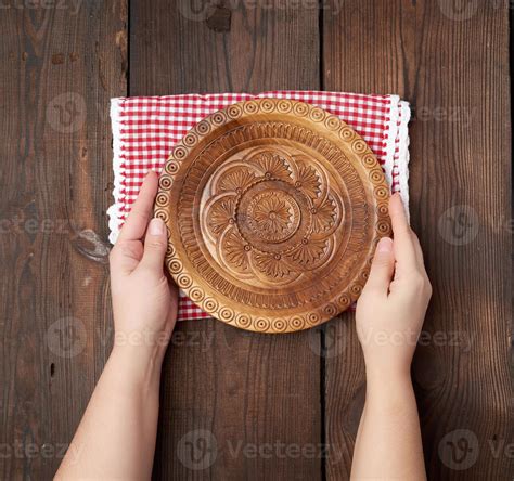 Two Female Hands Holding An Empty Round Wooden Plate Stock