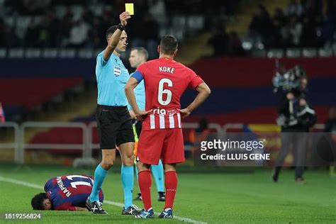 Spanish Referee Sanchez Martinez Presents A Yellow Card To Atletico