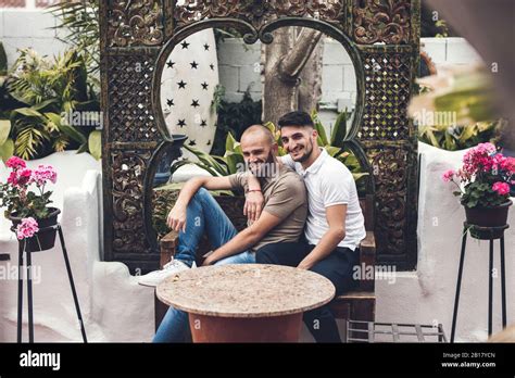 Happy Gay Couple Sitting Together On Bench On A Terrace Stock Photo Alamy