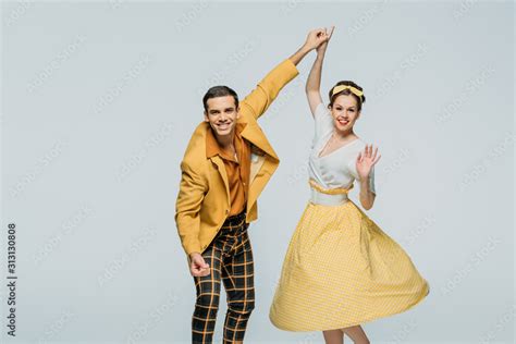 Happy Dancers Holding Hands While Dancing Boogie Woogie On Grey