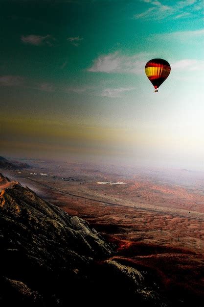 Premium Photo Hot Air Balloons Flying Over Landscape Against Sky