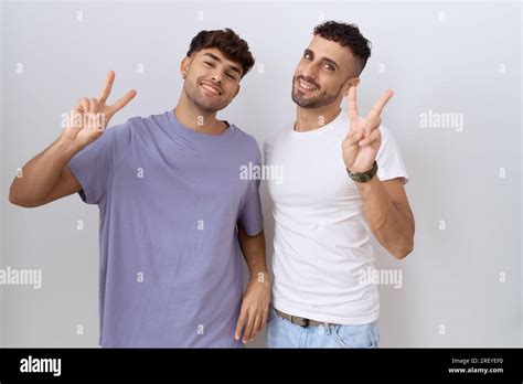 Homosexual Gay Couple Standing Over White Background Smiling Looking To The Camera Showing
