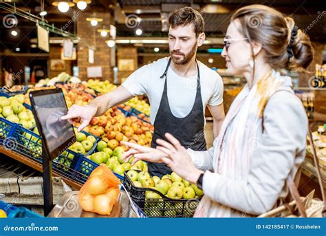 Mujer De Ayuda Del Trabajador Para Pesar Las Frutas En El Supermercado