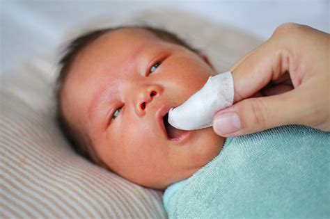 Mother Use Finger To Clean Baby Tongue And Gum With The Clean Gauze