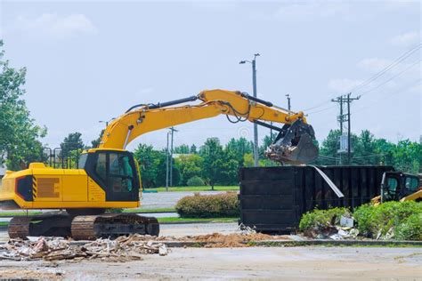 On Construction Site An Excavator Loads Construction Concrete Waste