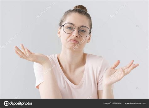 Indoor Photo Of Confused Young Female Wearing Trendy Hipster Eyeglasses Isolated On Grey