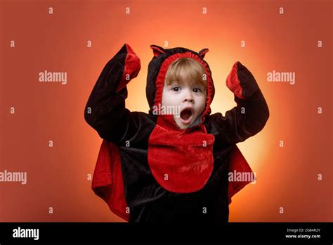 Happy kids on Halloween. Funny kids in carnival costumes on orange background. Scary face ...