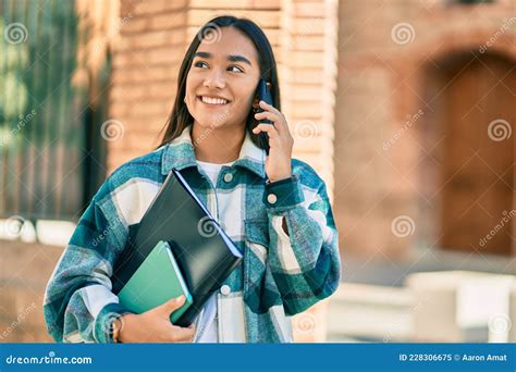 Joven Estudiante Latina Sonriendo Feliz Usando Un Smartphone En La Ciudad Imagen De Archivo