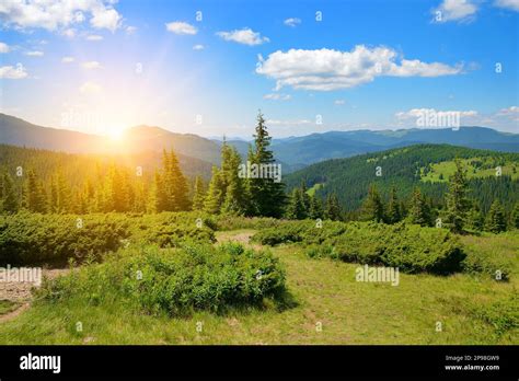 Beautiful bright sunrise in mountains and blue sky with white clouds ...