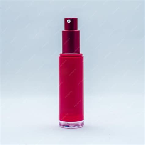 Premium Photo | A red bottle of perfume with a red cap on the top.