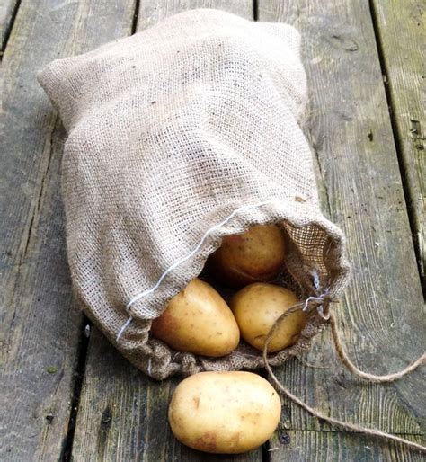 Potatoes In A Burlock Bag On A Wooden Table