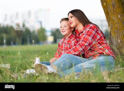 Maman Et Son Fils Assis Sur Le Couvre Lit Dans Ses Bras Et Regarder