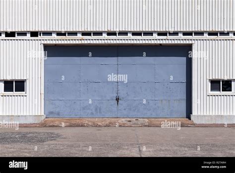 Closed blue gate in white ridged metal warehouse wall, flat background photo texture Stock Photo ...