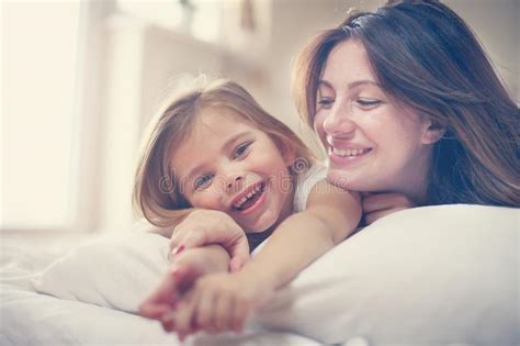 Mère Avec Sa Petite Fille Mignonne Se Trouvant Sur Le Lit Photo Stock