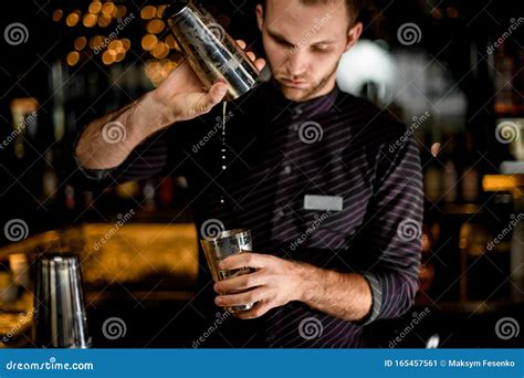 Male Bartender Pouring a Cocktail Drink from the One Half of the Steel ...