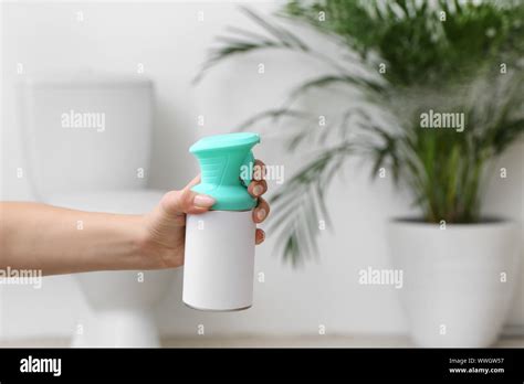 Woman spraying air freshener in bathroom Stock Photo - Alamy