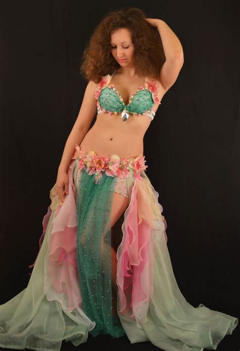 A Woman In A Green And Pink Belly Dance Costume With Flowers On Her