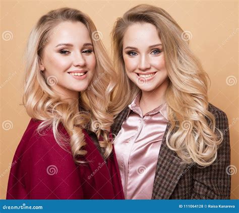 Fashion Portrait of Two Girls, Best Friends Posing Indoor on Beige Background Wearing Winter ...