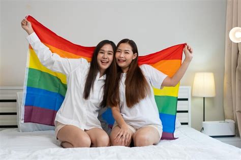 Premium Photo Portraits Of Happy Asian Lesbian Couple Sitting With Rainbow Flag Sitting Bed Beside
