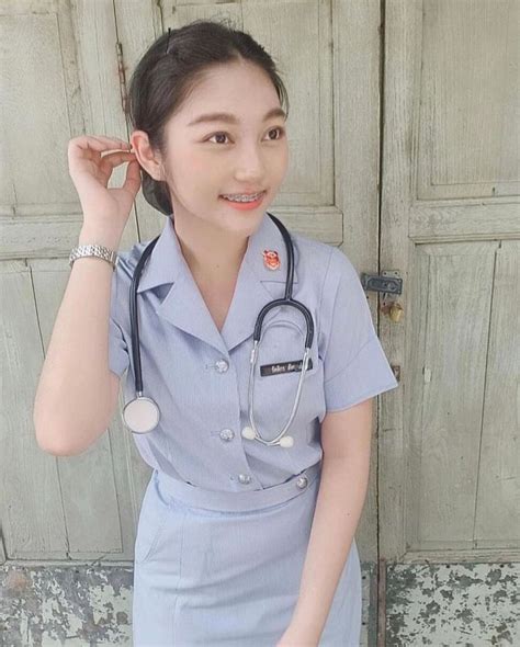 A Woman In A Nurses Uniform Standing Next To A Door With A Stethoscope On Her Head